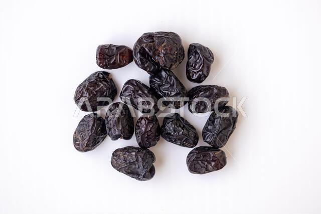 Ajwa dates fruit isolated on white background. Close-up of whole dried, dark brown, wrinkled dates. Natural, vegan, healthy Arabian dessert food for e