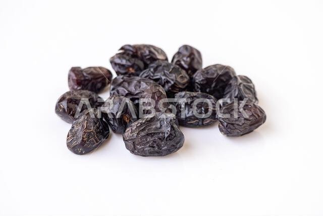 Delicious, healthy Ajwa dates isolated on a white background. Fresh, premium quality Ramadan fruit (Phoenix dactylifera) from Saudi Arabia. Sweet, nut