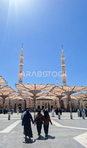 Medina, Saudi Arabia - March 7, 2024:  Pilgrims walk to the main mosque of the Prophet Muhammad Al-Masjid an-Nabawi preparing for prayer