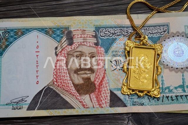 SAR Saudi Arabian riyals banknotes and gold bar with a flower motif pendant, 24K Gold Bar Half Ounce 15.55 Grams, pure fine gold 999.9, for investment