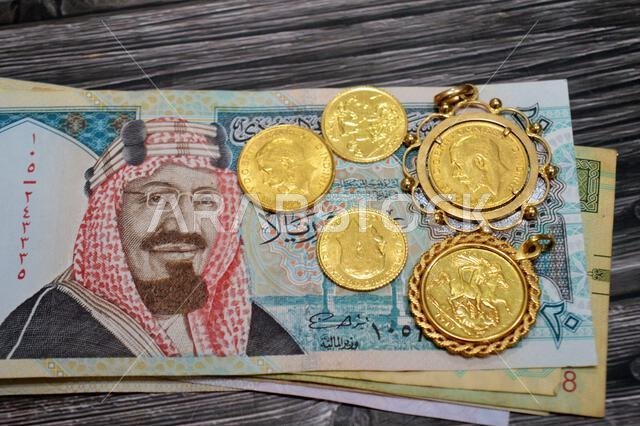 Saudi Arabian riyals money banknote bills and King George V gold sovereign coins, features King George V and the classic St. George and the Dragon, SA Saudi Arabian riyals money banknote bills and King George V gold sovereign coins, features King George V and the classic St. George and the Dragon, SA