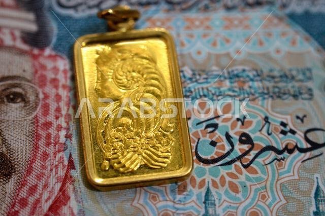 صورة مقرّبة لعملة الريال السعودي ونقش سيدة فورتونا على قلادة من الذهب عيار 24 قيراطًا، ذهب نقي عيار 999.9، للاستثمار صورة مقرّبة لعملة الريال السعودي ونقش سيدة فورتونا على قلادة من الذهب عيار 24 قيراطًا، ذهب نقي عيار 999.9، للاستثمار