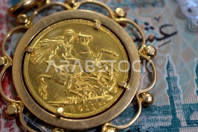 SAR Saudi Arabian riyals money and reverse side of King George V gold sovereign coin, features the classic St. George and the Dragon, sovereigns are p