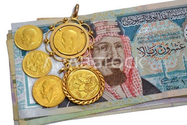 Saudi Arabian riyals money banknote bills and King George V gold sovereign coins, features King George V and the classic St. George and the Dragon, SA Saudi Arabian riyals money banknote bills and King George V gold sovereign coins, features King George V and the classic St. George and the Dragon, SA