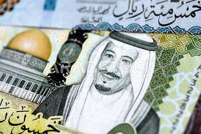 Saudi Arabia riyal money bills banknotes lies in big pile on table close up. Concept of finances and business in Saudi Arabia