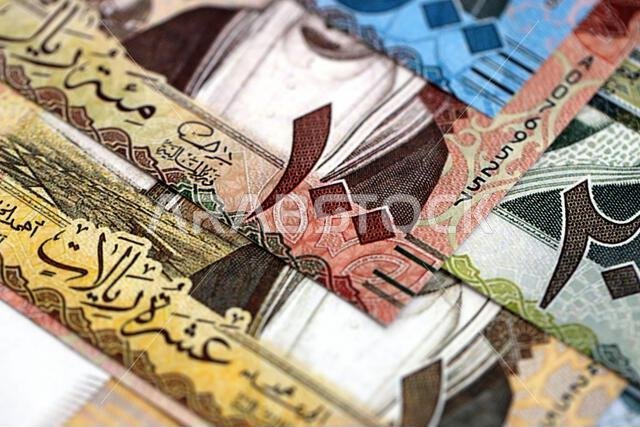 أوراق نقدية من الريال السعودي مكدسة في كومة كبيرة على طاولة، صورة مقرّبة. مفهوم التمويل والأعمال في المملكة العربية السعودية