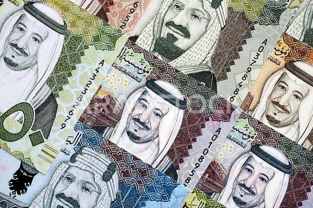 Saudi Arabia riyal money bills banknotes lies in big pile on table close up. Concept of finances and business in Saudi Arabia