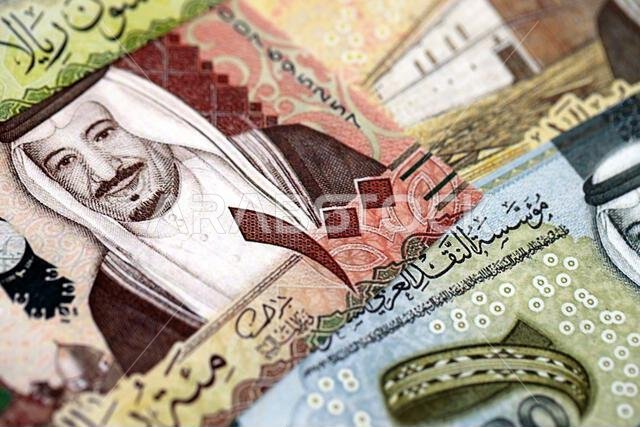 أوراق نقدية من الريال السعودي مكدسة في كومة كبيرة على طاولة، صورة مقرّبة. مفهوم التمويل والأعمال في المملكة العربية السعودية