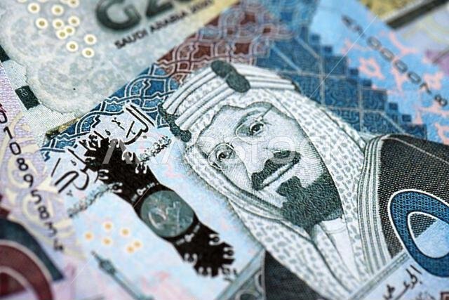 Saudi Arabia riyal money bills banknotes lies in big pile on table close up. Concept of finances and business in Saudi Arabia