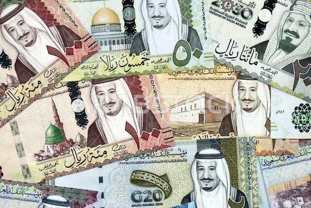 أوراق نقدية من الريال السعودي مكدسة في كومة كبيرة على طاولة، صورة مقرّبة. مفهوم التمويل والأعمال في المملكة العربية السعودية