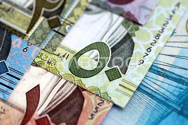 Saudi Arabia riyal money bills banknotes lies in big pile on table close up. Concept of finances and business in Saudi Arabia
