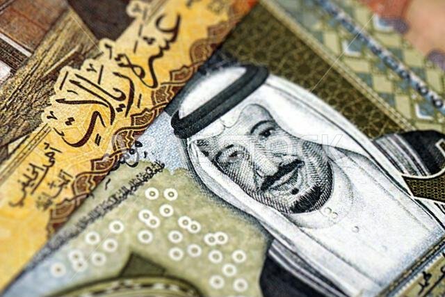 Saudi Arabia riyal money bills banknotes lies in big pile on table close up. Concept of finances and business in Saudi Arabia