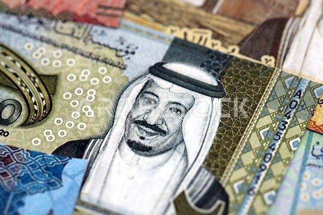 أوراق نقدية من الريال السعودي مكدسة في كومة كبيرة على طاولة، صورة مقرّبة. مفهوم التمويل والأعمال في المملكة العربية السعودية