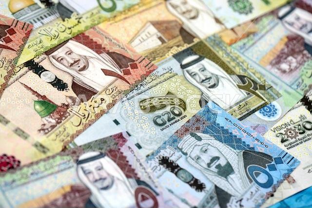 Saudi Arabia riyal money bills banknotes lies in big pile on table close up. Concept of finances and business in Saudi Arabia