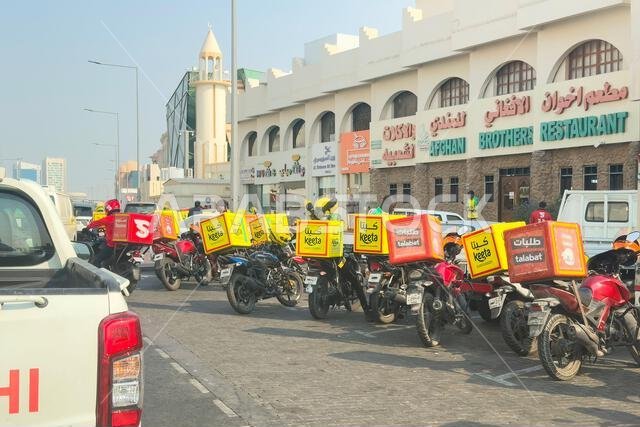 Doha, Qatar - November 14, 2025: Keeta riders, food delivery using bike, motorcycles parked out side restaurants.