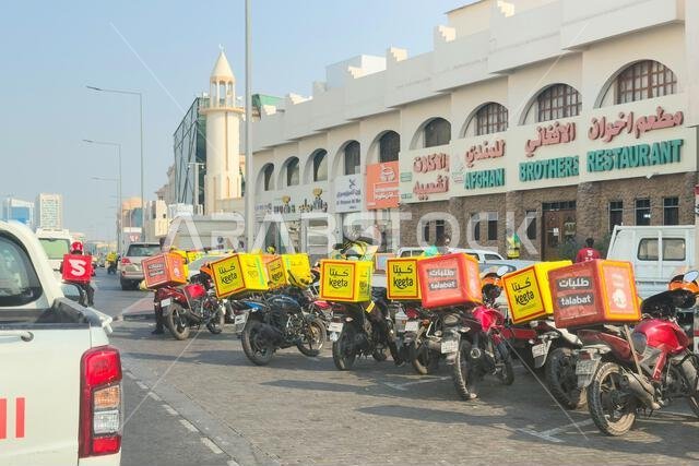 Doha, Qatar - November 14, 2025: Keeta riders, food delivery using bike, motorcycles parked out side restaurants.