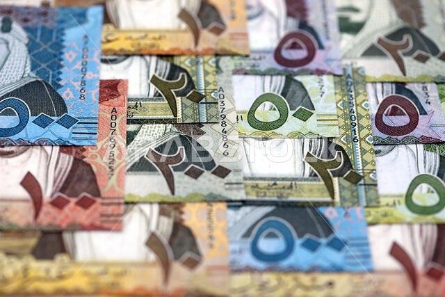 أوراق نقدية من الريال السعودي مكدسة في كومة كبيرة على طاولة، صورة مقرّبة. مفهوم التمويل والأعمال في المملكة العربية السعودية