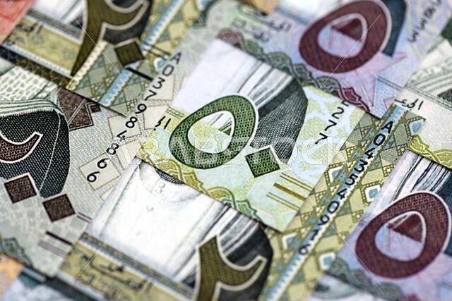 Saudi Arabia riyal money bills banknotes lies in big pile on table close up. Concept of finances and business in Saudi Arabia