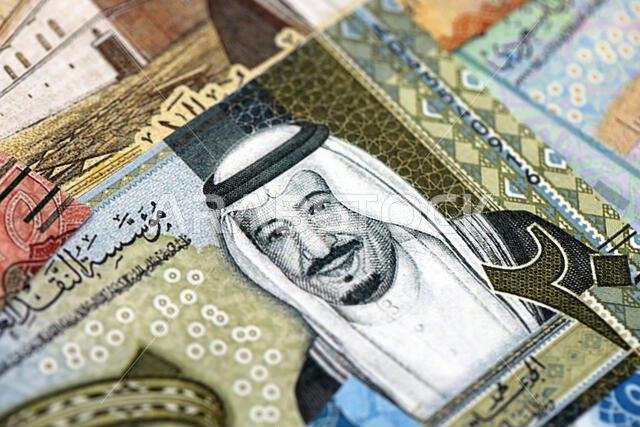 Saudi Arabia riyal money bills banknotes lies in big pile on table close up. Concept of finances and business in Saudi Arabia