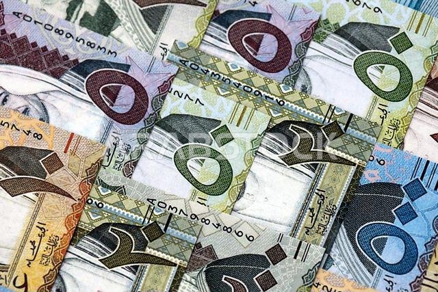 Saudi Arabia riyal money bills banknotes lies in big pile on table close up. Concept of finances and business in Saudi Arabia