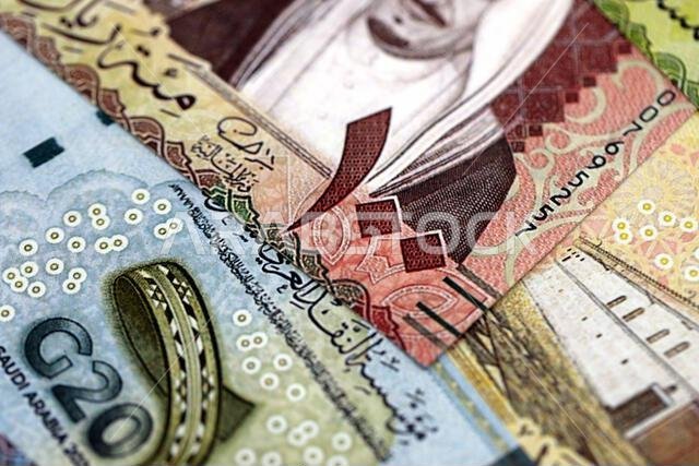 أوراق نقدية من الريال السعودي مكدسة في كومة كبيرة على طاولة، صورة مقرّبة. مفهوم التمويل والأعمال في المملكة العربية السعودية