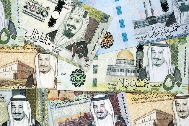 أوراق نقدية من الريال السعودي مكدسة في كومة كبيرة على طاولة، صورة مقرّبة. مفهوم التمويل والأعمال في المملكة العربية السعودية