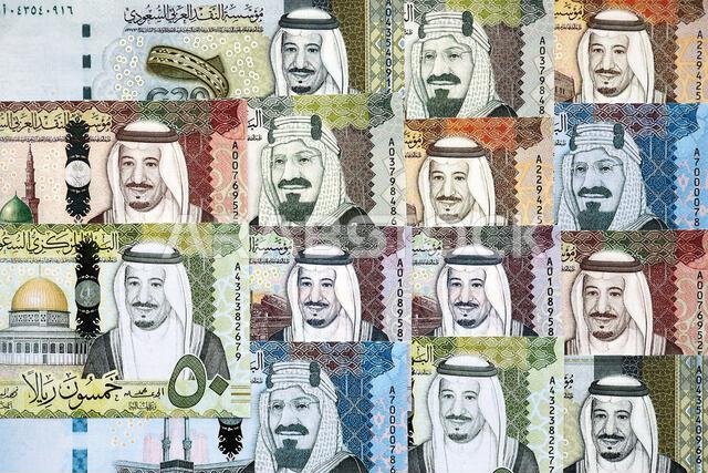 Saudi Arabia riyal money bills banknotes lies in big pile on table close up. Concept of finances and business in Saudi Arabia Saudi Arabia riyal money bills banknotes lies in big pile on table close up. Concept of finances and business in Saudi Arabia