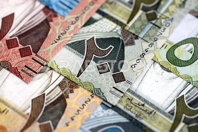 Saudi Arabia riyal money bills banknotes lies in big pile on table close up. Concept of finances and business in Saudi Arabia