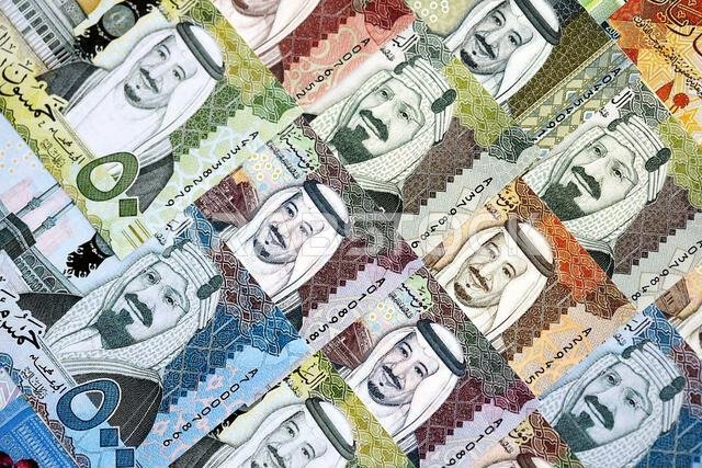 Saudi Arabia riyal money bills banknotes lies in big pile on table close up. Concept of finances and business in Saudi Arabia