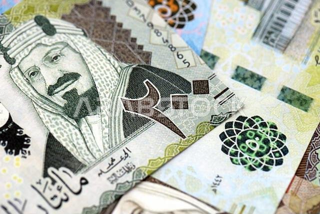 Saudi Arabia riyal money bills banknotes lies in big pile on table close up. Concept of finances and business in Saudi Arabia Saudi Arabia riyal money bills banknotes lies in big pile on table close up. Concept of finances and business in Saudi Arabia
