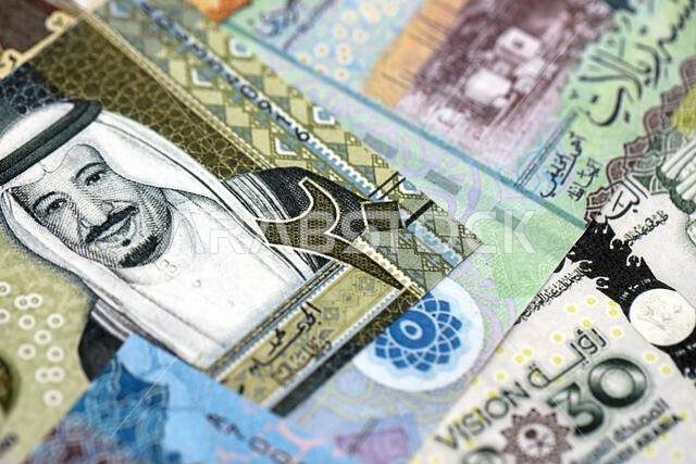 Saudi Arabia riyal money bills banknotes lies in big pile on table close up. Concept of finances and business in Saudi Arabia