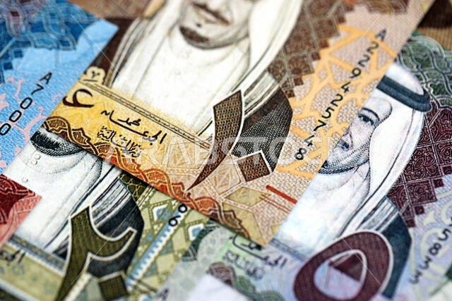 أوراق نقدية من الريال السعودي مكدسة في كومة كبيرة على طاولة، صورة مقرّبة. مفهوم التمويل والأعمال في المملكة العربية السعودية