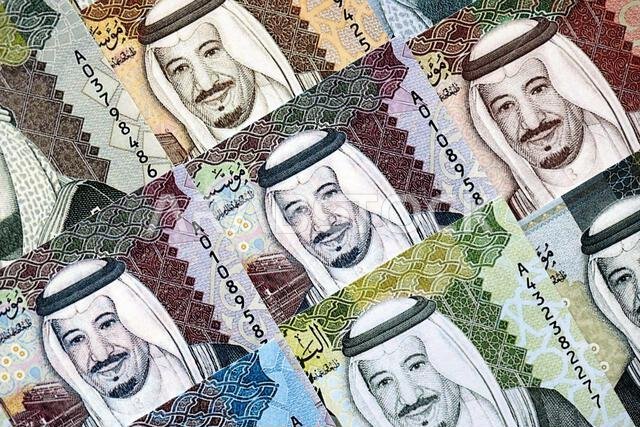 Saudi Arabia riyal money bills banknotes lies in big pile on table close up. Concept of finances and business in Saudi Arabia Saudi Arabia riyal money bills banknotes lies in big pile on table close up. Concept of finances and business in Saudi Arabia