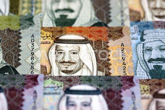 Saudi Arabia riyal money bills banknotes lies in big pile on table close up. Concept of finances and business in Saudi Arabia