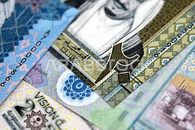 أوراق نقدية من الريال السعودي مكدسة في كومة كبيرة على طاولة، صورة مقرّبة. مفهوم التمويل والأعمال في المملكة العربية السعودية