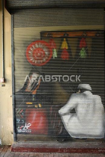 A corrugated metal shutter covered in graffiti at Souq-al-Zal in Riyadh, Saudi Arabia.