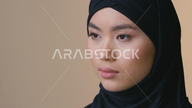 امرأة مسلمة ترتدي حجابًا أسود، تنظر بعيدًا بوجه جاد، تبدو في الداخل، سيدة مسلمة متأملة، وحيدة، حزينة، دين، عنصرية، تمييز، إيمان