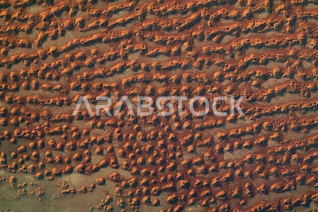 Sand dunes in the Rub' al Khali, or Empty Quarter, the largest contiguous sand desert in the world. The dunes are located along the border between Saudi Arabia and Oman. The Rub' al Khali covers parts of Saudi Arabia, Oman, Yemen, and the UAE. The dramatic lighting highlights the complex patterns and shadows of the massive dune field. Rub' Al Khali is the largest sand desert in the world, covering 650.000 square km in Saudi Arabia. A photograph taken from the International Space Station on 12 Ju