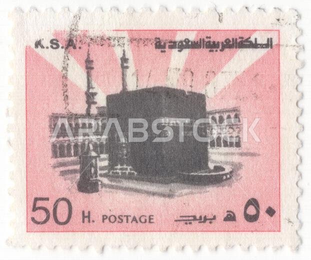 المملكة العربية السعودية - ١٩٧٨: طابع بريدي من فئة ٥٠ هلالة باللونين الوردي والأسود، يصور الكعبة المشرفة في قلب المسجد الحرام بمكة المكرمة. يظهر البناء المكعب الأسود، المغطى بالكسوة التقليدية المطرزة بالذهب، بشكل بارز في ساحة المسجد الحرام، مع ظهور الأروقة المحيطة والمآذن الشاهقة في الخلفية. تنبعث من خلف الكعبة أشعة بيضاء منمقة على خلفية سماء وردية، ترمز إلى الأهمية الروحية لهذا الموقع باعتباره أقدس مكان في العالم.