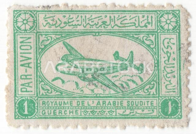 المملكة العربية السعودية - 1 أكتوبر 1949: طابع بريدي جوي أزرق مخضرّ من فئة 1 غرش، يصور طائرة إيرسبيد إيه إس 57 أمباسادور أثناء تحليقها. تظهر هذه الطائرة البريطانية الأنيقة، التي صُنعت بعد الحرب، من جانبها، مُبرزةً تصميمها المميز أحادي السطح ذي الجناح العلوي، والمثبتات الرأسية الثلاثية (الزعانف الذيلية) التي تميزها عن طائرتي دي سي-3 وبريستول 170. تبدو الطائرة وكأنها تصعد فوق منظر صحراوي مُنمّق. يحيط بالشكل البيضاوي المركزي إطار مستطيل مُزخرف يحمل نقوشًا تقليدية.