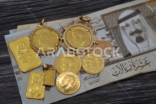 SAR Saudi Arabian riyals money banknotes and gold bars and The sovereign is a British gold coins, for investment or savings, 24 karat with highest lev