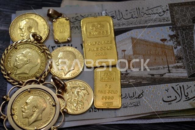 Cairo, Egypt, January 9 2026: Saudi Arabian riyals money banknotes SAR and Pamp Suisse gold bars and The sovereign is a British gold coins, for invest