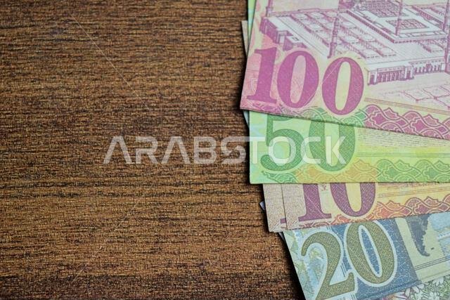 عملة سعودية على خلفية خشبية