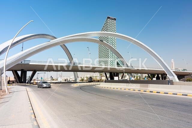 الرياض، المملكة العربية السعودية - 2 يناير 2026: وصف: يمتد جسر أنيق مقوس فوق طريق واسع أسفل فندق سوفيتيل الرياض الحديث ذي التصميم الشبكي.