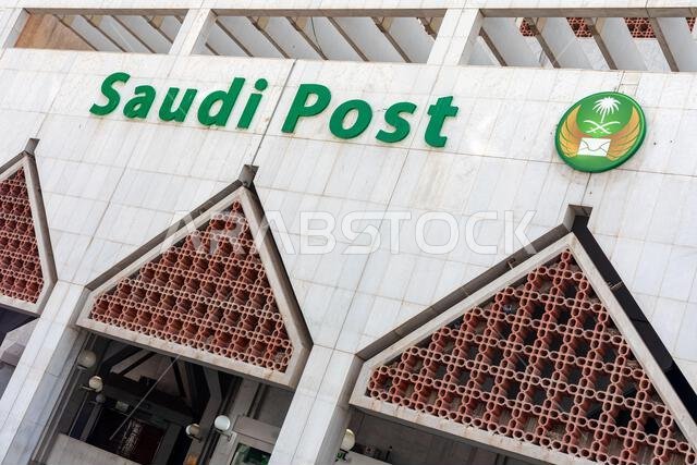 الرياض، المملكة العربية السعودية - ٢٢ ديسمبر ٢٠٢٥: مبنى بريدي حكومي حديث يتميز بشعار البريد السعودي الأخضر البارز وشعار دائري.