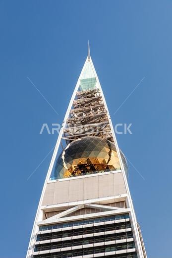 Riyadh, Saudi Arabia - January 1, 2026: A dramatic close-up of the Al Faisaliah Tower in Riyadh featuring a glass spire and geometric gold sphere, set