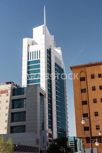 الرياض، المملكة العربية السعودية - 1 يناير 2026: ناطحة سحاب أنيقة بيضاء اللون، برج الواصل، فوق شارع مزدحم في المدينة، محاطة بمبنى بيج اللون.
