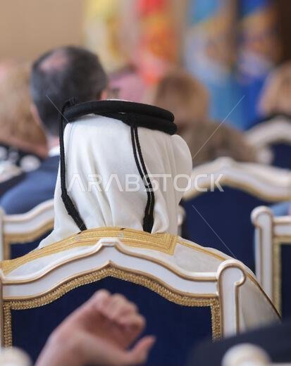 تفاصيل ذات عمق مجال ضحل مع رجل في الجمهور يرتدي غترة إسلامية، شماغ، كوفية، وهو وشاح قطني مربع مثبت بحبل أسود يسمى