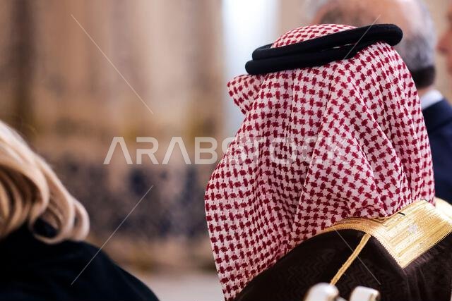 تفاصيل ذات عمق مجال ضحل مع رجل في الجمهور يرتدي غترة إسلامية، شماغ، كوفية، وهو وشاح قطني مربع مثبت بحبل أسود يسمى