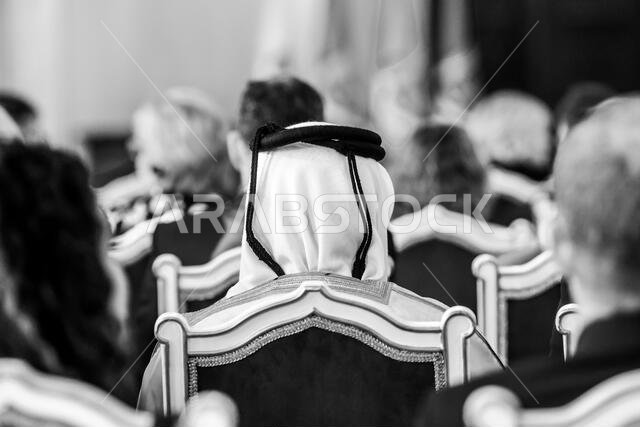 تفاصيل ذات عمق مجال ضحل مع رجل في الجمهور يرتدي غترة إسلامية، شماغ، كوفية، وهو وشاح قطني مربع مثبت بحبل أسود يسمى